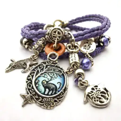 charm bracelet with charms: cat sitting on moon, tree of life, capital letter A, lavender sprig, killer whale, infinity  tattoo design idea