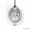 A heart-shaped pendant hanging from a dog paw print, representing love and loyalty towards pets tattoo design idea
