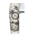 a clock sinking into the ocean with palm trees and a sun on the shore  tattoo design idea