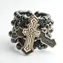 Black out line on a Finger ring of a rosary with the beads wrapped around the knuckles of the finger and the small cross tattoo design idea