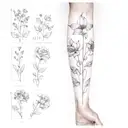 A sleeve tattoo featuring the birth flowers of February, March, April, May, September, and November in a dotwork style tattoo design idea