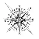 simple compass cross with arrow pointing North with small lotus flower in bottom right hand corner tattoo design idea